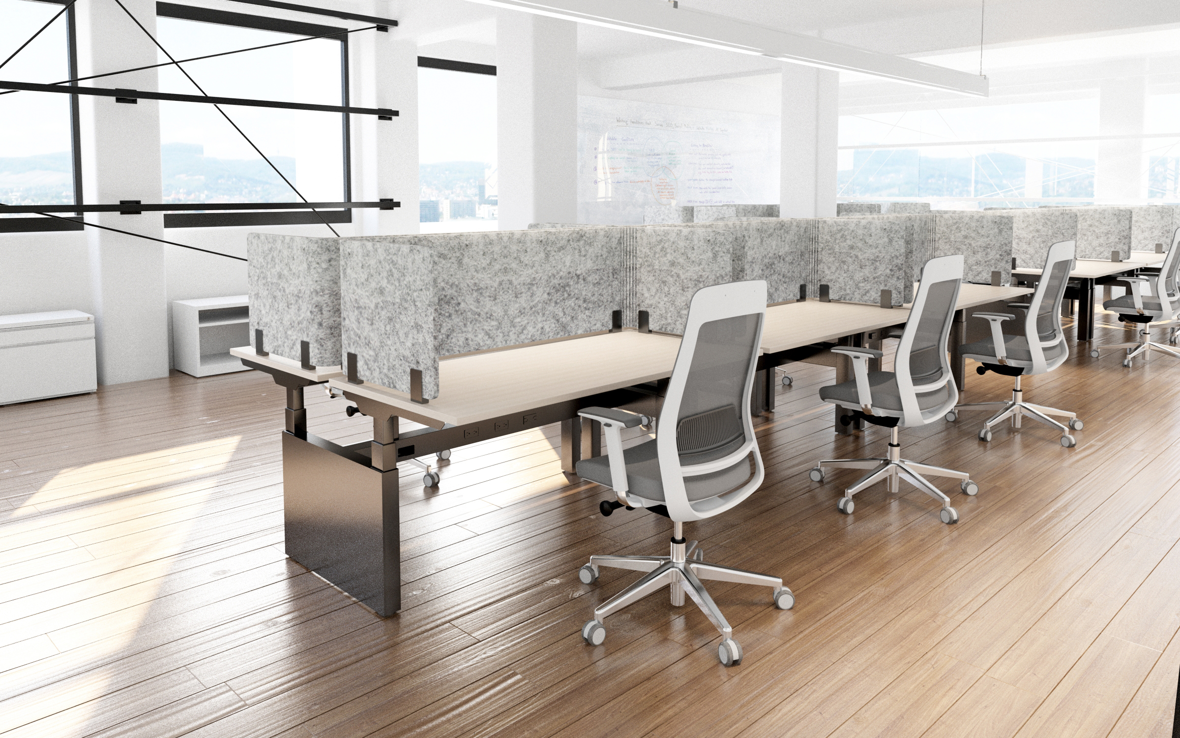 Row of adjustable desks with fabric privacy panels and ergonomic task chairs in an open-plan office with wood floors.