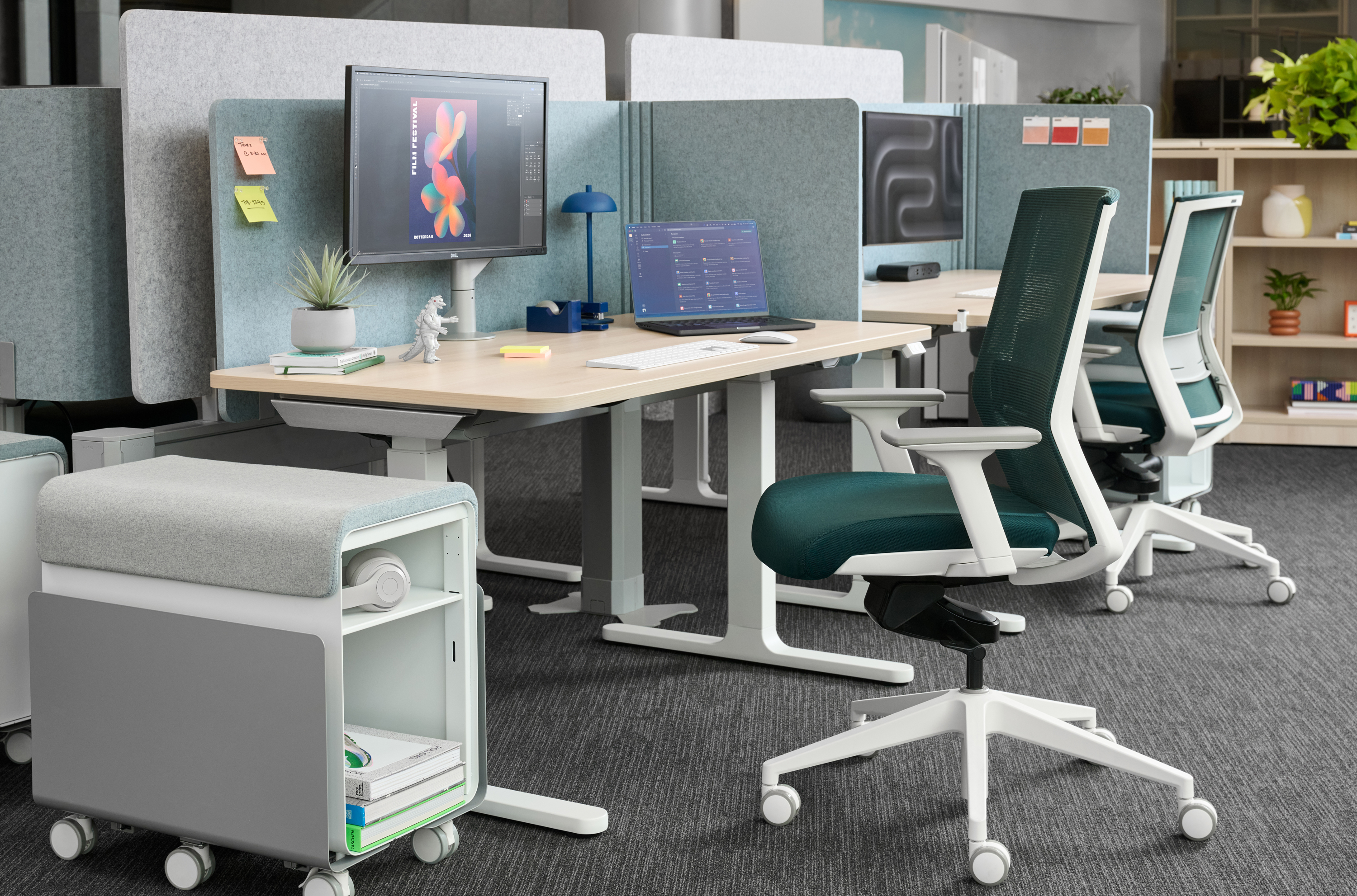 Modular office workstation with Adjustable Office Chairs, desk with monitor and laptop, partition panels in a modern open-plan office.