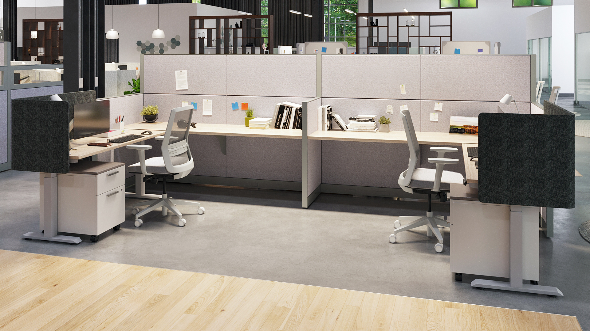 Two back-to-back office workstations with ergonomic chairs, monitors, and fabric cubicle panels in an open showroom.
